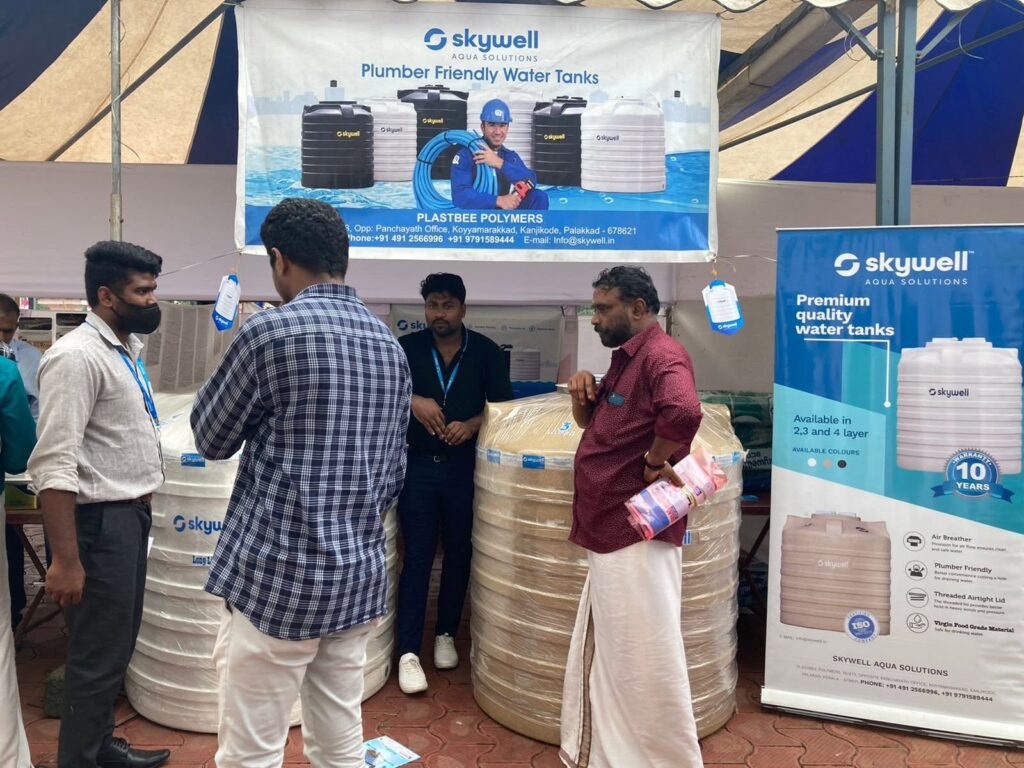 Skywell booth at a conference with water tanks, staff, visitors and product banners.
